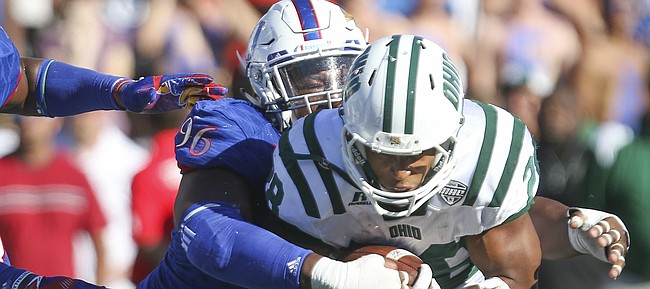 Kansas defensive tackle Daniel Wise (96) wraps up Ohio running back Dorian Brown (28) during the fourth quarter on Saturday, Sept. 10, 2016 at Memorial Stadium. At left is Kansas defensive end Dorance Armstrong Jr. (2).