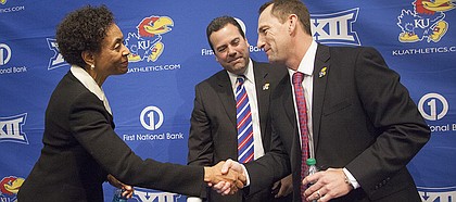 Kansas University chancellor Bernadette Gray-Little, left, shakes hands with new head football coach David Beaty, right, after an introductory press conference Monday, Dec. 8, 2014, at the Anderson Family Football Complex at KU in Lawrence, Kan. Beaty, the wide receivers coach and recruiting coordinator at Texas A&M, was hired by KU Friday. At center is Sheahon Zenger, KU director of athletics.