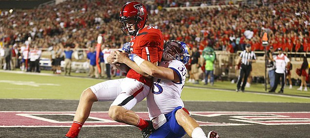 Kansas special teams player Keith Loneker (33) pulls down Texas Tech place kicker Erik Baughman (36) for a safety during the second quarter on Thursday, Sept. 29, 2016 at Jones AT&T Stadium in Lubbock, Texas.
