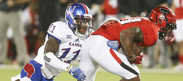 Kansas linebacker Mike Lee (11) tries to bring down Texas Tech wide receiver Cameron Batson (13) during the third quarter on Thursday, Sept. 29, 2016 at Jones AT&T Stadium in Lubbock, Texas.