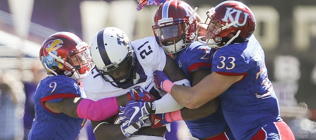 Kansas defenders Fish Smithson, (9), Greg Allen and Keith Loneker Jr. (33) bring down TCU running back Kyle Hicks (21) during the fourth quarter on Saturday, Oct. 8, 2016 at Memorial Stadium.