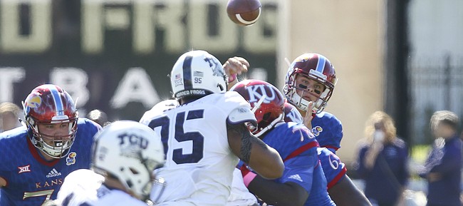 Kansas quarterback Ryan Willis throw from behind a pile of players during the first quarter on Saturday, Oct. 8, 2016 at Memorial Stadium.