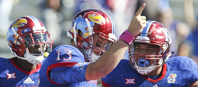 Kansas quarterback Ryan Willis (13) celebrates a touchdown with teammates Steven Sims Jr. (11) and D'Andre Banks (62) during the third quarter on Saturday, Oct. 8, 2016 at Memorial Stadium.