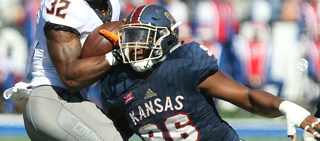 Kansas defensive tackle Daniel Wise (96) looks to bring down Oklahoma State running back Chris Carson (32) during the second quarter on Saturday, Oct. 22, 2016 at Memorial Stadium.