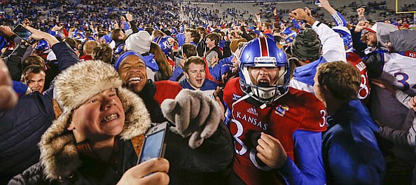 Kansas fans and players go crazy on the field following the Jayhawks' 24-21 overtime upset of Texas on Saturday, Nov. 19, 2016 at Memorial Stadium.