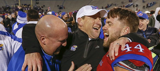 Kansas head coach David Beaty is flanked by fullback Michael Zunica (44) and offensive line coach Zach Yenser following the Jayhawks' 24-21 overtime upset of Texas on Saturday, Nov. 19, 2016 at Memorial Stadium.