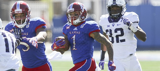 Kansas wide receiver LaQuvionte Gonzalez (1) gets a block from teammate Bobby Hartzog Jr. (5) as he runs for a 70-yard gain during the third quarter on Saturday, Oct. 8, 2016 at Memorial Stadium.