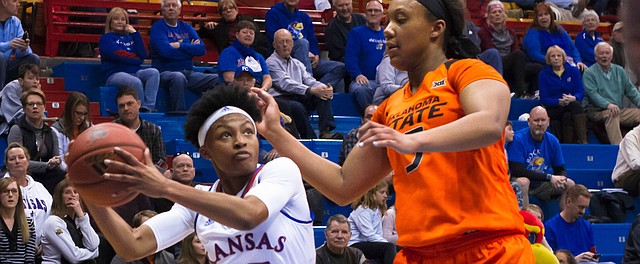 Kansas’ Aisia Robertson (15) goes up for the layup over Oklahoma State’s Diana Omozee (5) Wednesday at Allen Fieldhouse.