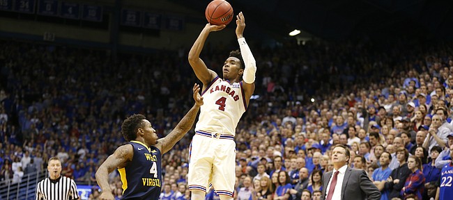 Kansas guard Devonte' Graham (4) hits a three over West Virginia guard Daxter Miles Jr. (4) in overtime, Monday, Feb. 13, 2017 at Allen Fieldhouse.