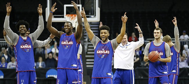 The Jayhawks celebrate a half-court shot by teammate Devonte' Graham during a day of practices and press conferences prior to Thursday's game at Sprint Center in Kansas City, Mo.