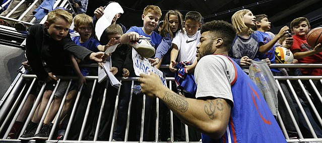 Kansas guard Frank Mason III (0) signs autographs for young Jayhawk fans during a day of practices and press conferences prior to Thursday's game at Sprint Center in Kansas City, Mo.