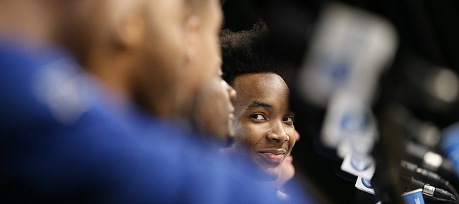 Kansas guard Devonte' Graham (4) smiles as he looks across the dais at his teammates while talking with media members during a press conference on Friday, March 24, 2017 at Sprint Center.