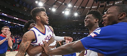 Kansas guard Frank Mason III (0) is hoisted up by teammate Josh Jackson as he is congratulated by center Udoka Azubuike and forward Dwight Coleby after Mason hit the game-winning shot to beat Duke 77-75 during the Champions Classic on Tuesday, Nov. 15, 2016 at Madison Square Garden in New York.