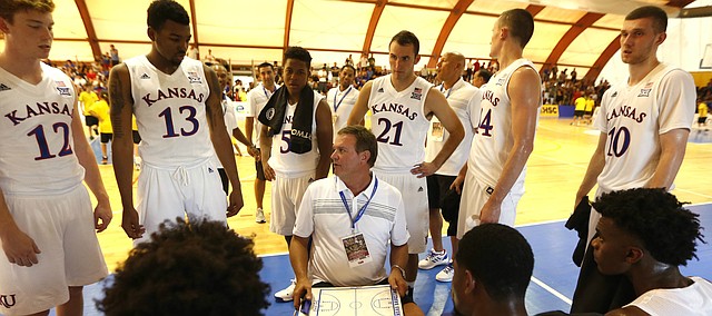 Kansas University's head coach Bill Self, center, gives suggestions to his players during a pause of a basketball game against HSC Roma in Rome, Wednesday, Aug. 2, 2017. (AP Photo/Riccardo De Luca)