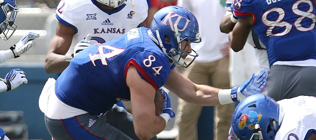 Team KU tight end Ben Johnson (84) braces himself as he prepares for a hit from Team Jayhawks safety Emmanuel Moore (20) during the third quarter of the 2017 Spring Game on Saturday, April 15 at Memorial Stadium.