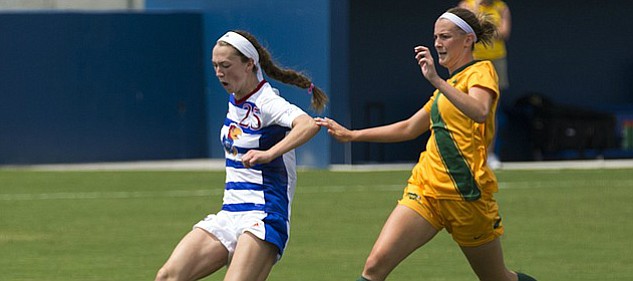After beating North Dakota State freshman defender Hanna Norman, right, Kansas freshman Grace Hagan (25) sends the ball into the back of the net for her second first half goal during their exhibition soccer match Sunday at Rock Chalk Park. 