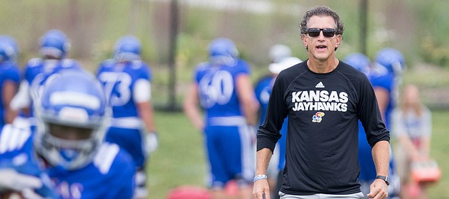 Kansas offensive coordinator and receivers coach Doug Meacham watches over a drill during practice on Monday, Aug. 14, 2017 at the grass fields adjacent to Hoglund Ballpark.