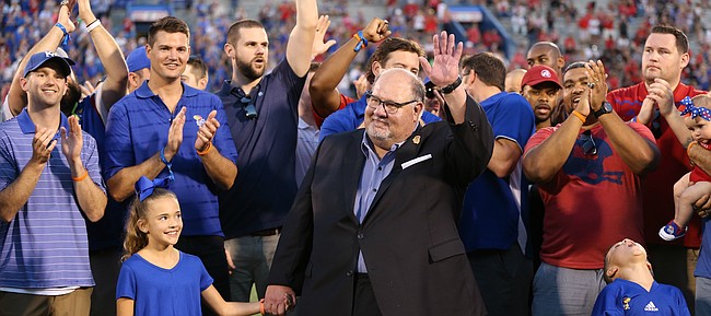 Former Kansas head football coach Mark Mangino and members of the 2008 Orange Bowl team wave to fans as they are recognized during a halftime ceremony, Saturday, Sept. 2, 2017 at Memorial Stadium.