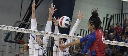 Kansas sophomore Zoe Hill hits the ball into Creighton's block, which was set by freshman Naomi Hickman (21, a Free State alumna) and junior Jaali Winters (5), in the second set of the Jayhawks' 25-20, 25-16, 29-27 loss to the Bluejays on Saturday in the Horejsi Family Athletics Center.