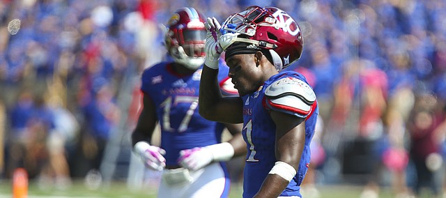 Frustrated, Kansas safety Mike Lee pulls off his helmet as he makes his way to the sidelines after a West Virginia touchdown during the second quarter on Saturday, Sept. 23, 2017 at Memorial Stadium.