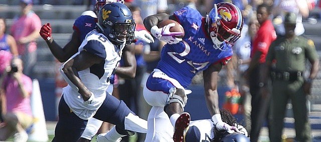 Kansas running back Taylor Martin (24) pushes off of West Virginia cornerback Mike Daniels Jr. (4) on a run during the second quarter on Saturday, Sept. 23, 2017 at Memorial Stadium.