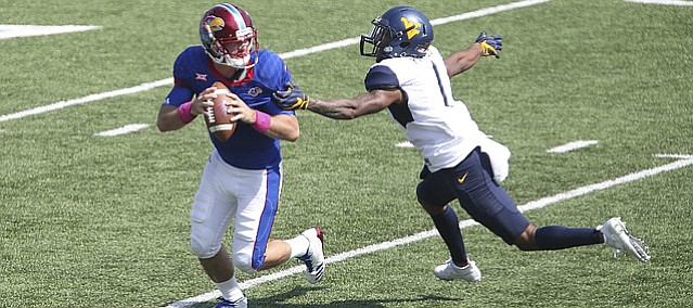 Kansas quarterback Peyton Bender (7) rolls out to pass as he is pressured by West Virginia safety Derrek Pitts (1) during the fourth quarter on Saturday, Sept. 23, 2017 at Memorial Stadium.