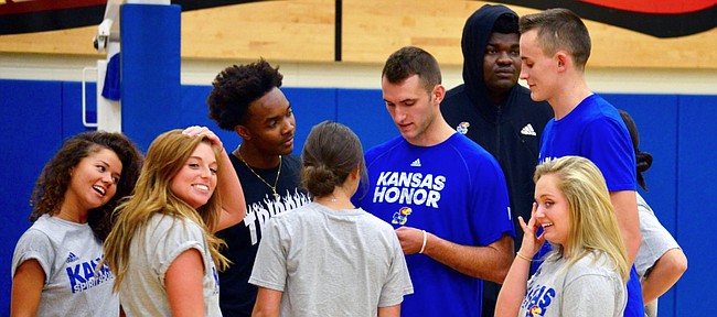 KU men's basketball players (left to right) Devonte' Graham, Clay Young, Udoka Azubuike and Mitch Lightfoot huddle alongside a group of Rock Chalk Dancers in preparation for Late Night in the Phog.