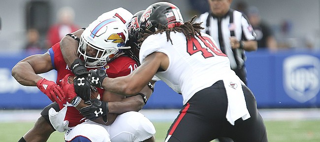 Kansas running back Khalil Herbert (10) is stopped short of a first down by Texas Tech linebacker Dakota Allen (40) and another Red Raider player during the first quarter on Saturday, Oct. 7, 2017 at Memorial Stadium.