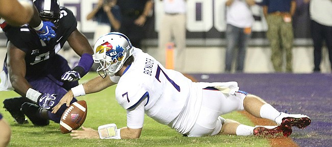 Kansas quarterback Peyton Bender (7) recovers a fumbled snap before TCU defensive tackle L.J. Collier (91) during the second quarter, Saturday, Oct. 21, 2017 at Amon G. Carter Stadium in Fort Worth.