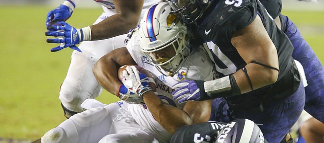 Kansas running back Khalil Herbert (10) is driven to the ground by TCU defensive tackle Ross Blacklock (90) and TCU safety Ridwan Issahaku (31) during the second quarter, Saturday, Oct. 21, 2017 at Amon G. Carter Stadium in Fort Worth.