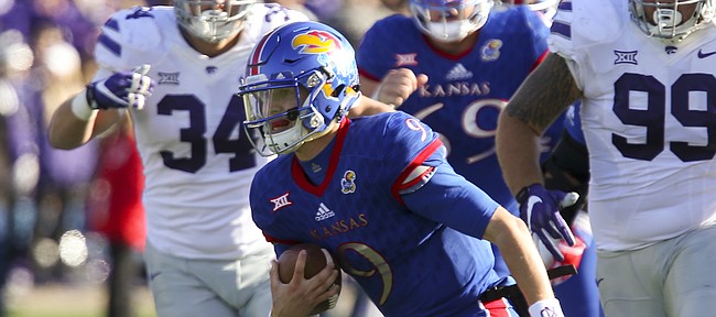 Kansas quarterback Carter Stanley (9) escapes on a run during the second quarter on Saturday, Oct. 28, 2017 at Memorial Stadium.