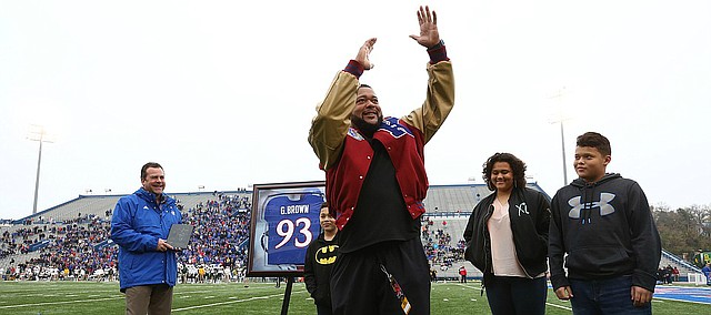 Kansas football great Gilbert Brown performs his signature tackle celebration for the Memorial Stadium crowd during a ceremony unveiling his name in the ring of honor on Saturday, Sept. 4, 2017.