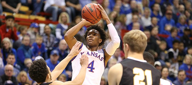 Kansas guard Devonte' Graham (4) pulls up for a three over Fort Hays State guard Aaron Nicholson (1) during the first half, Tuesday, Nov. 7, 2017 at Allen Fieldhouse.