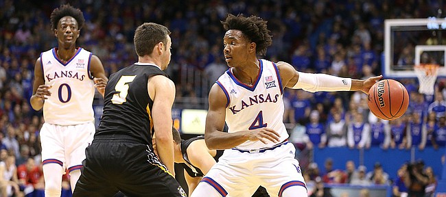 Kansas guard Devonte' Graham (4) regains his dribble while defended by Fort Hays State guard Kyler Kinnamon (5) during the first half, Tuesday, Nov. 7, 2017 at Allen Fieldhouse.