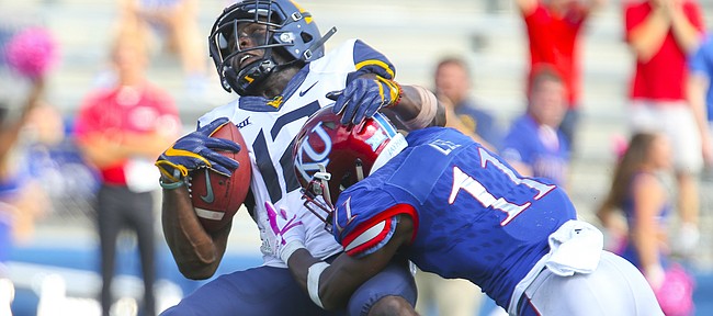 West Virginia wide receiver Gary Jennings (12) is drilled by Kansas safety Mike Lee (11) after a deep catch during the fourth quarter on Saturday, Sept. 23, 2017 at Memorial Stadium.