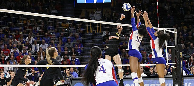 Missouri right outside hitter Melanie Crow (1) spikes the ball over the Kansas blockers. Kansas lost to Missouri in five sets in the first round of the NCAA Championship in Charles Koch Arena on Dec. 1, 2017.
