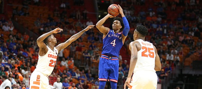 Kansas guard Devonte' Graham (4) pulls up for a three against Syracuse guard Frank Howard (23) and Syracuse guard Tyus Battle (25) during the second half, Saturday, Dec. 2, 2017 at American Airlines Arena in Miami.