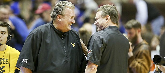 Kansas head coach Bill Self and West Virginia head coach Bob Huggins have a laugh before tipoff on Monday, Jan. 15, 2018 at WVU Coliseum in Morgantown, West Virginia. Self sported a Huggins-style pullover given to him by Huggins before the game.