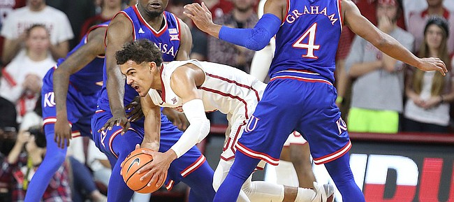 Kansas guard Devonte' Graham (4) and Kansas center Udoka Azubuike (35) look to tie up Oklahoma guard Trae Young (11) during the first half at Lloyd Noble Center on Tuesday, Jan. 23, 2018 in Norman, Oklahoma.