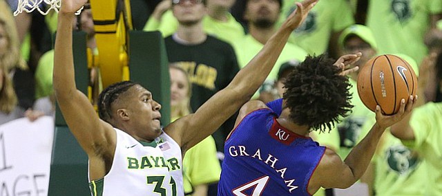 Kansas guard Devonte' Graham (4) is defended by Baylor Bears forward Terry Maston (31) on the shot during the second half, Saturday, Feb. 11, 2018 at Ferrell Center in Waco, Texas.