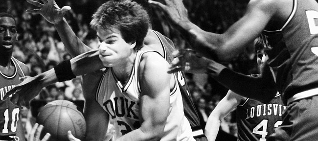 Jay Bilas, center, of Duke is surrounded by Louisville players as he struggles to keep the ball during the first half of the NCAA Championship game at Reunion Arena in Dallas, April 1, 1986. (AP Photo/Ron Heflin)