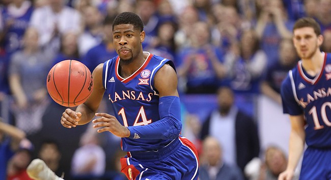 Kansas guard Malik Newman (14) comes away with a  ball from West Virginia forward Logan Routt (31) during the first half, Saturday, Feb. 17, 2018 at Allen Fieldhouse.