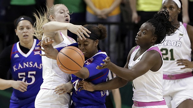 Baylor's Lauren Cox, left, and Dekeiya Cohen, right, combine to strip the ball away from Kansas' Austin Richardson, center, in the second half of an NCAA college basketball game Saturday, Feb. 17, 2018, in Waco, Texas. (AP Photo/Tony Gutierrez)