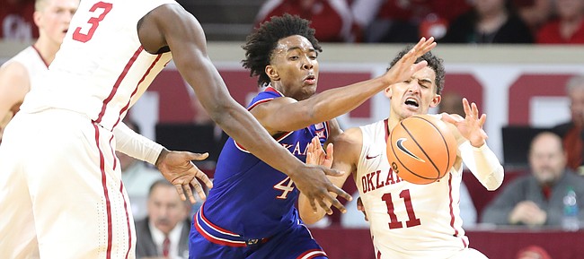 Kansas guard Devonte' Graham (4) is called for a foul on Oklahoma guard Trae Young (11) while trying to knock away a pass from Oklahoma forward Khadeem Lattin (3) during the second half at Lloyd Noble Center on Tuesday, Jan. 23, 2018 in Norman, Oklahoma.