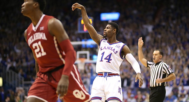 Kansas guard Malik Newman (14) hangs his arm in the air after a three over Oklahoma forward Kristian Doolittle (21) during the first half, Monday, Feb. 19, 2018 at Allen Fieldhouse.