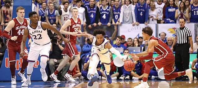 Kansas guard Devonte' Graham (4) strips a pass going to Oklahoma guard Trae Young (11) during the second half, Monday, Feb. 19, 2018 at Allen Fieldhouse.