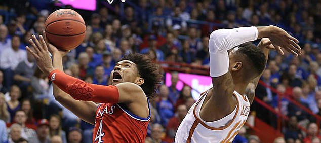 Kansas guard Devonte' Graham (4) elevates to the bucket past Texas guard Kerwin Roach II (12) during the first half on Monday, Feb. 26, 2018 at Allen Fieldhouse.