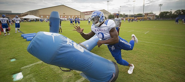 Kansas defensive end Dorance Armstrong hits a dummy while running through a drill during practice on Friday, Aug. 18, 2017 at the grass fields adjacent to Hoglund Ballpark.