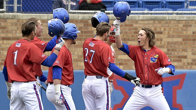 Kansas freshman Skyler Messinger, right, celebrates with his teammates Sunday, March 11, 2018, following a series sweep of St. John’s.