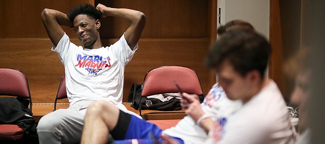 Kansas guard Marcus Garrett smiles as he listens to questions being asked of other players in the team locker room during a day of practices and press conferences at Intrust Bank Arena in Wichita, Kan.